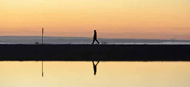 Persona caminando, amanecer, piletón, agua, obra, reflejo en el agua